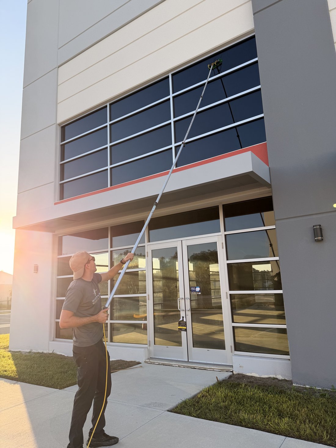 Water-fed pole cleaning a commercial building